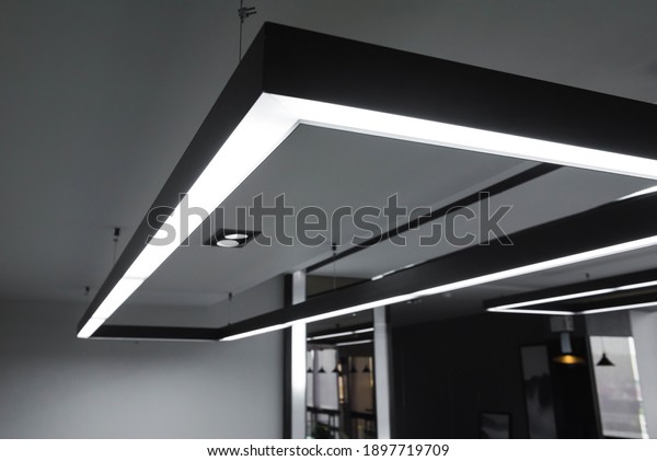 LED white cold light over workplaces. Modern\
office lighting.