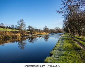 Leeds Liverpool Canal Frozen In Winter With Frosty Towpath And Blue Sky