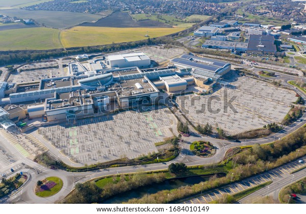 Leeds UK, 26th March 2020: Aerial photos of the
white rose shopping centre located in the village of Beeston in
Leeds showing the large shopping centre and carparks,  taken on a
summer bright day.
