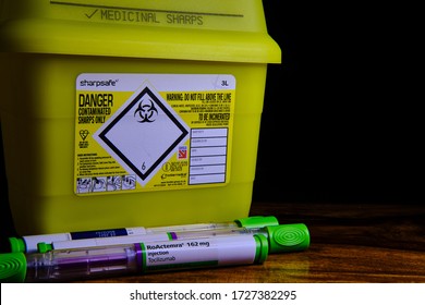 LEEDS, UNITED KINGDOM - Apr 10, 2020: Horizontal Shot Of Tocilizumab Arthritis Healing Injections Laid In Front Of A Bright Yellow Sharps Bin