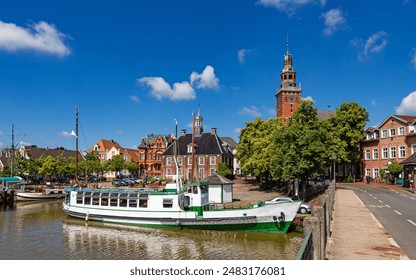 Leer, Germany. Panoramic view from Leda river on city hall, historic weighing house in dutch classical baroque style, tourist harbor and bridge.