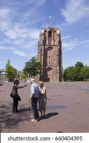 Leeuwarden, Netherlands, 11 June 2017: Young Black Man Talks To Older Couple Near Old Lopsided Tower Oldehove In The Center Of Ancient City Leeuwarden In The Netherlands