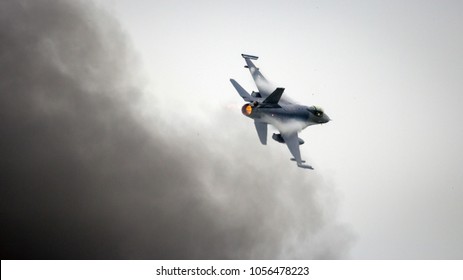 LEEUWARDEN, THE NETHERLANDS - JUN 10, 2016: Dutch F-16 fighter jet flying near black smoke during an air power demonstration at the Royal Netherlands Air Force Days 