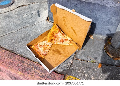 Left Behind Thrown Away Discarded Slices Of Cheese Pizza In Container Box On Road Street Sidewalk Outside Outdoors Food Waste In Key West, Florida