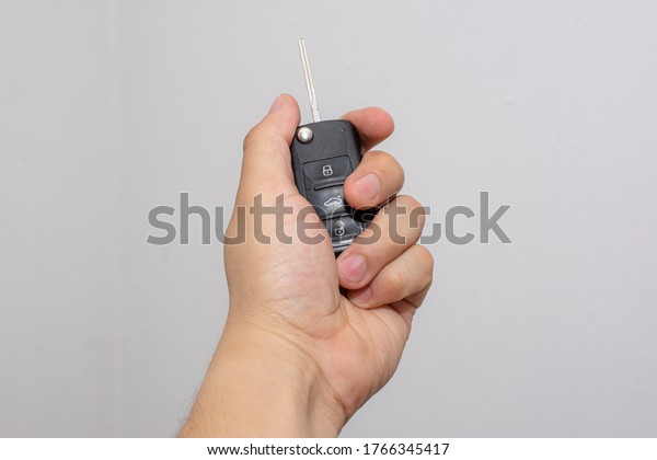 

Left hand holding electronic car keys on
isolated white
background