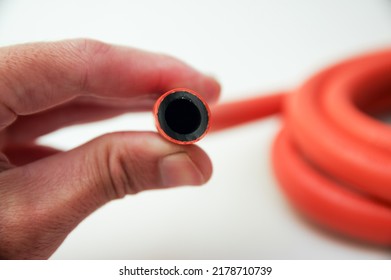 Left Hand Holding Orange Gas Hose,closeup And Isolated 