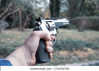 A Left Hand Holds A Big Silver Revolver In The Air