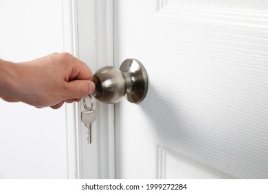 Left Hand Of A Man Unlocking Door With Key