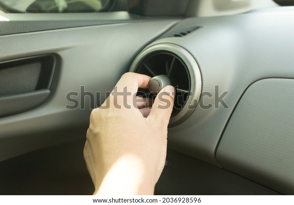 Left hand touches the air conditioner to rotate the\
inside of the car.