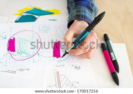 Left handed designer making a rough sketch of a system solution during the product design process 