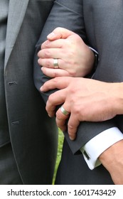 The Left Hands Of A Same Sex Gay Couple Showing Their Weddings Rings.