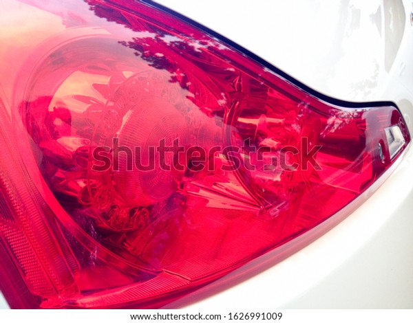 Left rear red brake light close-up shiny\
smooth reflections