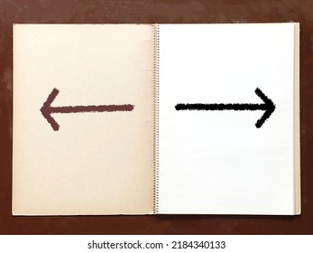 Left And Right Arrows On An Open Old Sketchbook On A Desk.