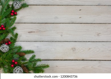 A Left Side Border Of Spruce Boughs, Red Berry Clusters, Silver Twig Balls,  And Spruce Pine Cones