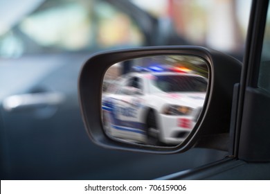 Left Side Car Mirror Showing Police Car In Motion