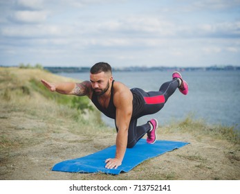 Left Side Of Strong Man Practices Yoga Outside, Near The River, On Green Mountain. Male Training, Hardowking Person