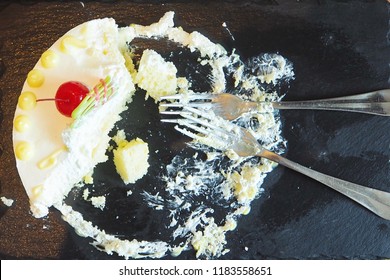 Leftover Cake On The Black Plate With Forks In The Refrigerator. Unhealthy Food, High Calories Food, Diabetes And Dessert Concept