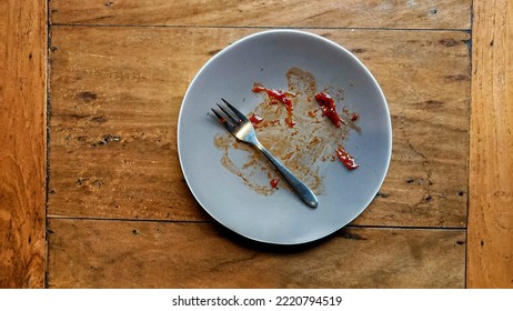 The Leftover Food And Dirty Dishes On The Wooden Table.

