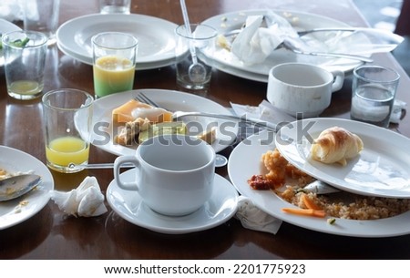 The leftover food and dirty dishes on the restaurant table. Scraps left over after the breakfast. ストックフォト © 