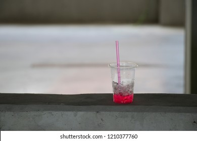 Leftover Iced Drink With Straw In Clear Plastic Cup. Non-biodegradable Waste.