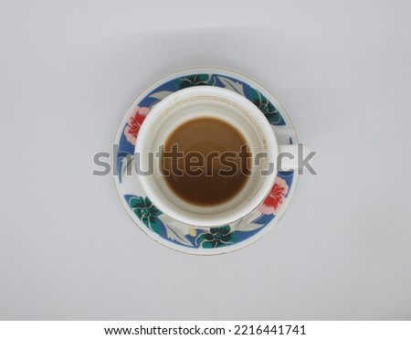 leftover milk-cream coffee in a white and blue floral-patterned cup. top view  ストックフォト © 