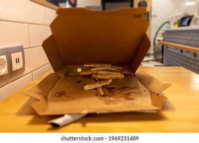 Leftover Pieces Of Pizza Crust Laying In The Pizza Box Carton. Leftovers Pizza In A Cafe