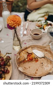 Leftover Tomato Pie On A Platter With Crumbs. Details Of A Picnic Table With Food. Two Slices Of Tomato Galette On A Plate