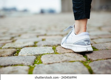 Leg Of Female Jogger Walking On Pavement. Focus Of Shoes. Woman Feet On Sidewalk.