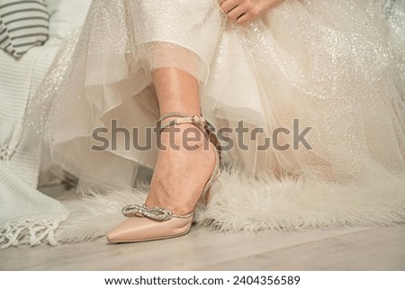 A leg in a heel of a sickly color, a girl in a white dress after wearing heels for a long time was reflected by the sickly look of the legs - beauty requires sacrifices