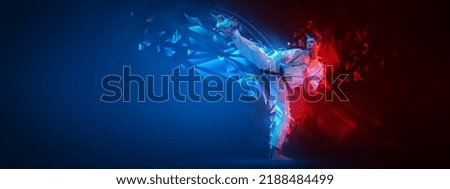 Leg kick. Collage with active young man, karate fighter in white kimono in action, motion isolated on blue-red background with neoned elements. Sport, action, combat sports, ad concept