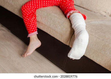 Leg In Plaster Of A Teenage Girl On A Sofa After An Accidental Fall With An Ankle Fracture