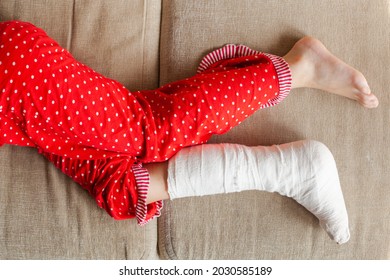 Leg In Plaster Of A Teenage Girl On A Sofa After An Accidental Fall With An Ankle Fracture