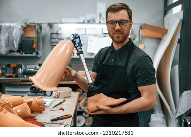 Leg prosthesis in hands. Technician working indoors. - Powered by Shutterstock