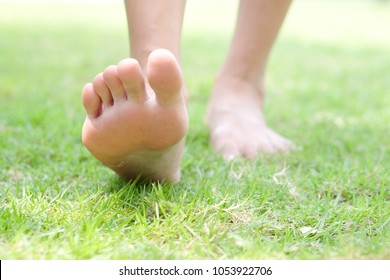 Leg of woman is on the ground. She is about to walk down the grass to exercise in the morning. Health and Relaxation Concepts