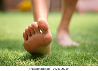 Leg of woman is on the ground. She is about to walk down the grass to exercise in the morning. Health and Relaxation Concepts - Powered by Shutterstock