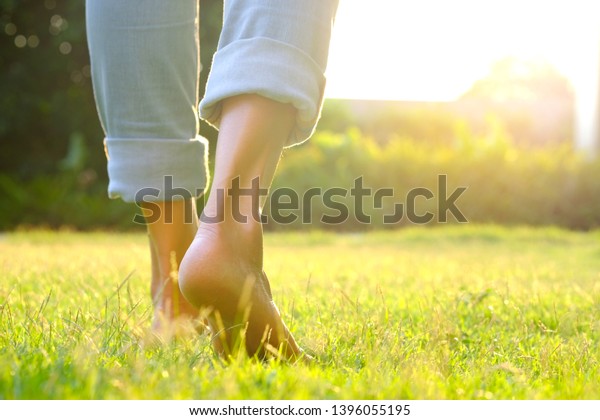 Leg of woman is on  to\
walk down the grass to exercise in the morning. Health and\
Relaxation Concepts