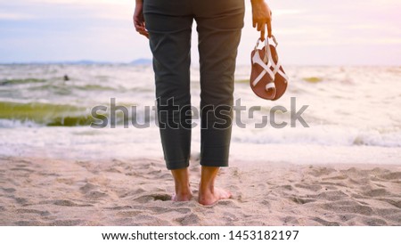  leg of young women with shoes on the beach in the summer