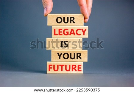 Legacy and future symbol. Concept words Our legacy is your future on wooden blocks. Beautiful grey table grey background. Businessman hand. Business legacy and future concept. Copy space.