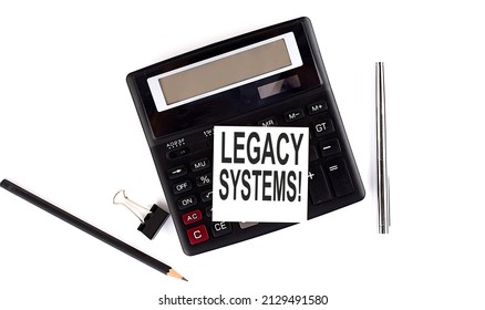 LEGACY SYSTEM text on sticker on calculator with pen,pencil on white background