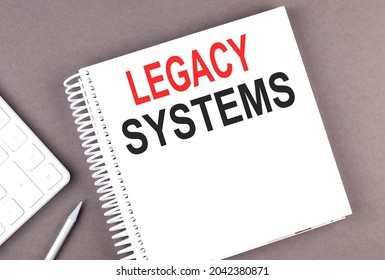 LEGACY SYSTEMS text on notebook with calculator and pen