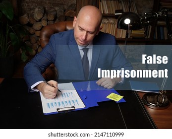 Legal Concept About False Imprisonment Male Office Workers With Yellow Shirt Holding And Writing Documents On Office Desk
