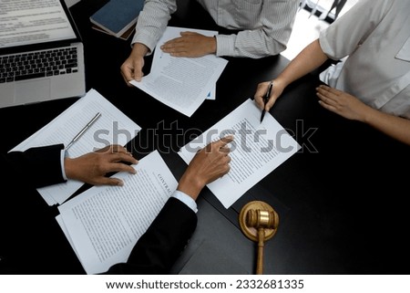 At a legal consultation meeting a lawyer is pointing out legal matters to guide him in solving a lawsuit or drafting a contract in a law firm.
