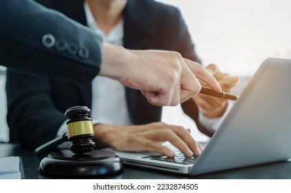 Legal counsel presents to the client a signed contract with gavel and legal law. justice and lawyer concept in office. - Shutterstock ID 2232874505