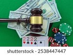 Legal gambling setup with cash, poker chips, cards, and a gavel on a green surface