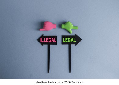 Legal illegal Business symbol. Concept words Legal or illegal on beautiful signpost with two arrows. Beautiful grey background. Toy hands are pointers. Entscheidung Verbot kriminell erlaubt verboten P - Powered by Shutterstock