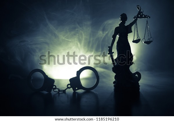 法律のコンセプト 霧の多い背景に赤と青の点滅する警察灯を持つ手錠のシルエットと正義の像の背景 限定フォーカス の写真素材 今すぐ編集