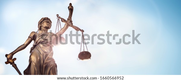 Legal and law concept statue of Lady\
Justice with scales of justice and sky\
background