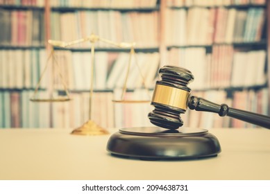 Legal Office Of Lawyers, Justice And Law Concept : Judge Gavel Or A Hammer And A Base Used By A Judge Person On A Desk In A Courtroom With Blurred Weight Scale Of Justice, Bookshelf Background Behind	