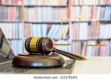 Legal office of lawyers, justice and law concept : Judge gavel or a hammer and a base used by a judge person on a desk in a courtroom with blurred weight scale of justice, bookshelf background behind. - Shutterstock ID 2151795391