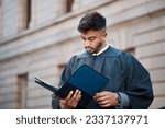 Legal, research and a lawyer man reading documents on a city street in preparation of a court case or trial. Law, study and information with a young attorney getting ready for a judgement or verdict